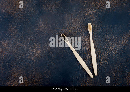 two wooden eco brushes with natural bristles on dark concrete background. Plastic free set. Zero waste, eco friendly concept. Stock Photo