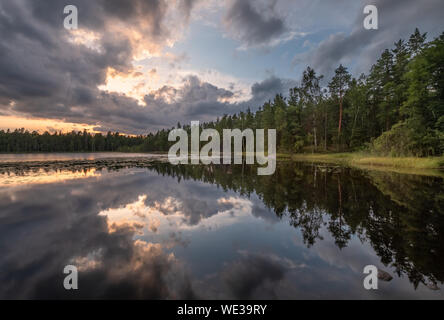 Scenic lake landscape with tranquility mood, sunset and beautiful reflections at summer evening in Finland Stock Photo