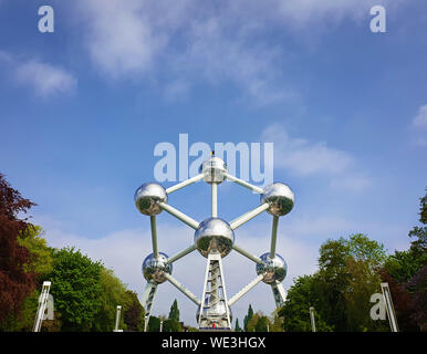 Famous Atomium landmark between trees alley over a blue sky background in Brussels, Belgium. Stock Photo