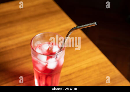 reusable metal straw in a glass of strawberry syrup drink Stock Photo