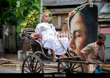 poor man pulling rich man in rickshaw in kolkata Stock Photo