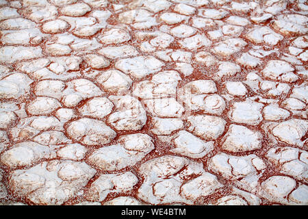 Cracked white dry clay and orande sand texture surface close up top view in Namib Desert, Southern Africa Stock Photo