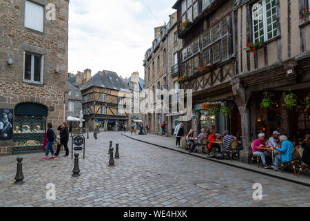Dinan, Brittany, France - June 20, 2019: Cobbled historic street Place des Merciers in Dinan with people dining at restaurants on a summer day Stock Photo