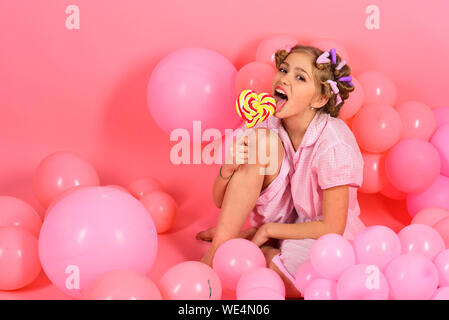 Party balloons, kid in curlers, pajama fashion. Stock Photo