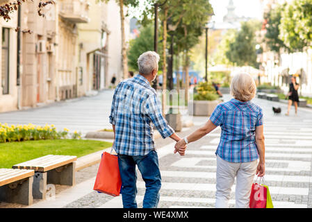 Senior couple with shopping bags walking after shopping Stock Photo