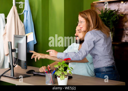 Two employees discuss the business plan. IT shows him something on the computer Stock Photo