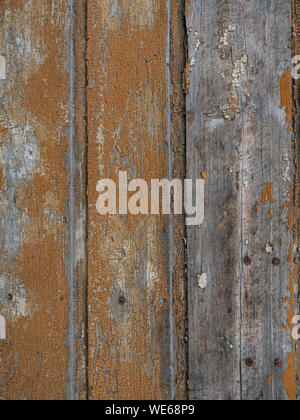 An old wooden wall texture with peeling faded brown paint Stock Photo