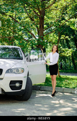 Beautiful girl opens the door of her car Stock Photo