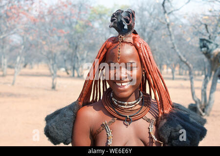 Otjikandero Himba Village, Namibia - September 8, 2017: Beautiful himba young girl with national traditional hairstyle, rings, necklace and bracelets Stock Photo