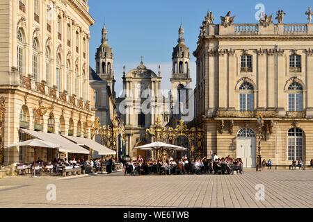 France, Meurthe and Moselle, Nancy, place Stanislas (former Place Royale) built by Stanislas Leszczynski, king of Poland and last duke of Lorraine in the eighteenth century, classified World Heritage of UNESCO, terrace of the hotel cafe Le Grand Hôtel with the cathedral Notre-Dame-de-l'Annonciation Stock Photo