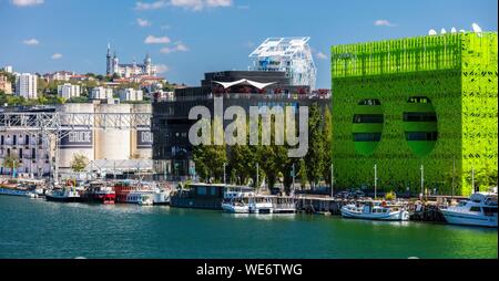 France, Rhone, Lyon, district of La Confluence in the south of the peninsula, first French quarter certified sustainable by the WWF, view of the quai Rambaud along the old docks with the Green Cube, the Ycone tower, the Sucriere and Notre Dame de Fourviere Basilica Stock Photo