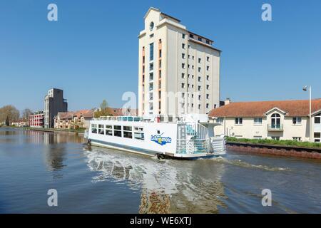 France, Meurthe et Moselle, Nancy, former grain silos (1941-1942) now apartment buildings on the Meurthe canal and river cruise boat La Bergamotte Stock Photo