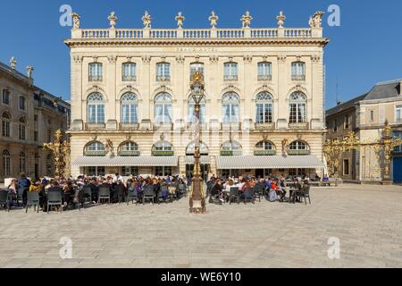 France, Meurthe et Moselle, Nancy, Stanislas square (former royal square) built by Stanislas Lescynski, king of Poland and last duke of Lorraine in the 18th century, listed as World Heritage by UNESCO, terrace and facade of the Grand Hotel de la Reine, street lamps and railings ironworks by Jean Lamour, facade of the Opera house to the left Stock Photo