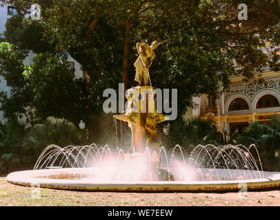 Fountain at Gabriel Miro plaza in Spanish city of Alicante at Costa Blanca surrounded by green palm trees historical landmarks in bright sunlight Stock Photo