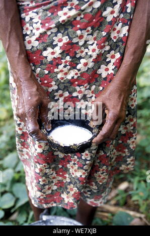 Midsection Of Woman Holding Latex In Coconut Shell
