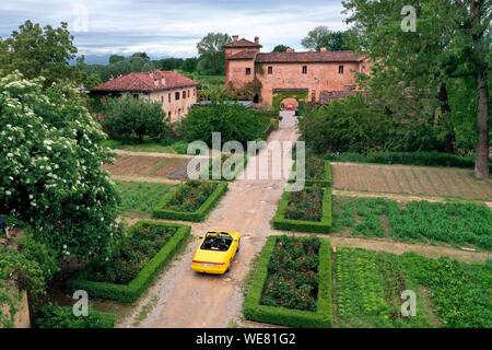 Italy, Emilia Romagna, Polesine Zibello near Parma, Antica Corte Pallavicina Hotel and restaurant, Alfa Romeo Duetto Spider yellow cabriolet (aerial view) Stock Photo