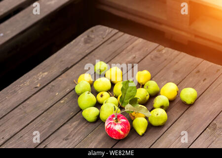 Apples and pears on a wooden background, in the garden, close-up Stock Photo