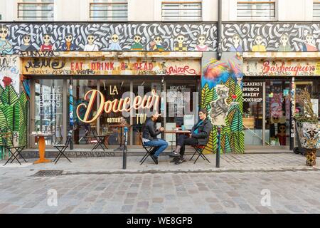 France, Paris, street art, graffitis and murals in Rue Denoyez, the terrace of the Barbouquin, cafe and bookstore Stock Photo