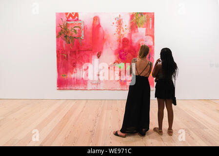 Whitney Museum, view of two young women looking at a painting by Jennifer Packer (A Lesson In Longing), Whitney Museum Of American Art, New York City. Stock Photo