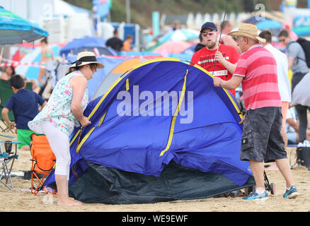 Bournemouth Dorset 30th August 2019. UK weather: Beachgoers on Bournemouth Beach brave a windy start to the day. Credit Stuart Martin/ Alamy Live News Stock Photo