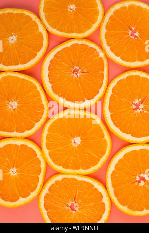 Background of sliced ripe oranges on a pink background vertical.  Stock Photo