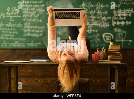 Home tutor helping boy with studies using modern laptop, Friendly teacher and adult smiling student in classroom, Great teacher conveys sense of leade Stock Photo