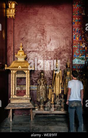 APR 5 Luang Prabang, Laos - Tourist exploring and looking at antique old Buddha statues at Wat  Xieng thong museum.  Most Famous tourist attraction in Stock Photo