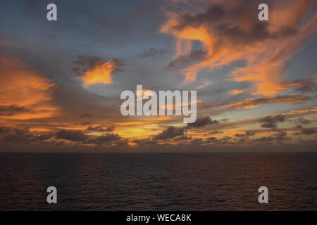 Dramatic sunset with clouds and sun rays over Caribbean sea - colorful sunset light rays - clouds and sun rays | sun rays - Caribbean Sunset Stock Photo