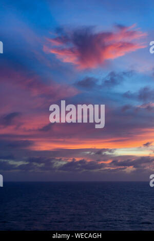 Dramatic sunset with clouds and calm sea - Caribbean sea - colorful sunset and calm ocean - pink clouds and orange clouds in Caribbean Sunset Stock Photo