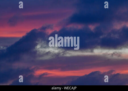 Dramatic sunset with dark clouds and pink clouds during blue hour - colorful Caribbean Sunset Stock Photo