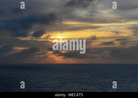 Dramatic sunset with clouds and sun rays over Caribbean sea - colorful sunset light rays - clouds and sun rays | sun rays - Caribbean Sunset Stock Photo