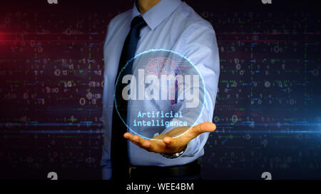 Man with dynamic artificial intelligence symbol hologram on hand. Businessman and futuristic concept of cybernetic brain, deep learning and cyber mind Stock Photo