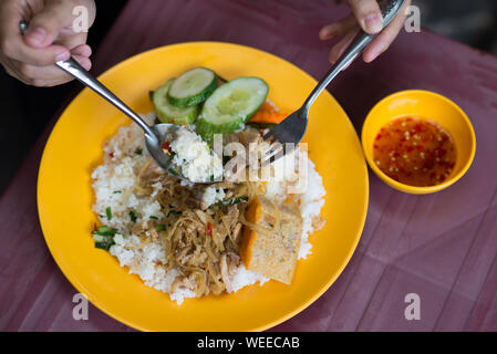 People eating delicious Vietnamese broken rice com tam Stock Photo