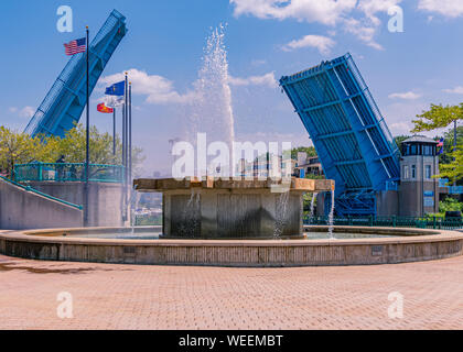 Millennium Park Fountain with Washington Park Bridge in the up position as boat traffic passes through in the summer. Stock Photo