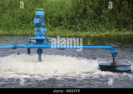 Water treatment by adding oxygen to the water using a propeller to hit the bubbles. Stock Photo