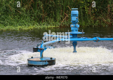 Water treatment by adding oxygen to the water using a propeller to hit the bubbles. Stock Photo