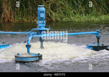 Water treatment by adding oxygen to the water using a propeller to hit the bubbles. Stock Photo