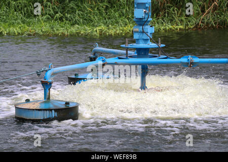 Water treatment by adding oxygen to the water using a propeller to hit the bubbles. Stock Photo