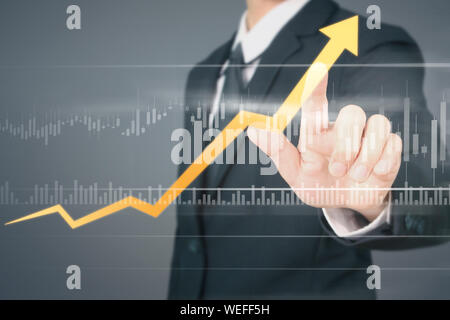 Businessman Hand Touching stock Graph Indicating Growth Stock Photo