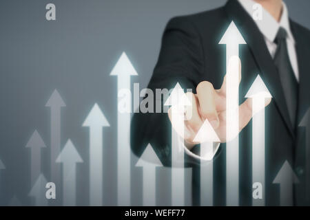 Businessman Hand Touching stock Graph Indicating Growth Stock Photo