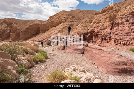 tourists enjoying the red sandstone boulders on a hike in the red canyon near eilat in israel Stock Photo