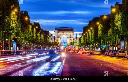 Illuminated Champs Elysee and view of Arc de Triomphe in parisian evening, France Stock Photo