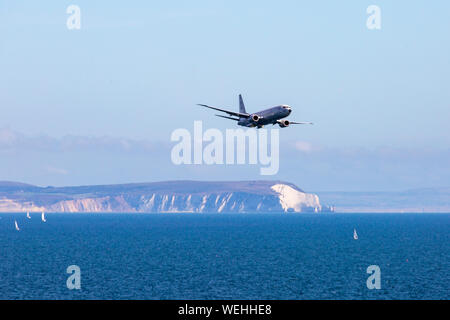 Bournemouth, Dorset UK. 30th August 2019. P-8A Poseidon Surveillance Aircraft - Boeing plane specifically developed for the US Navy and modified from the Boeing 737-800 does fly past at Bournemouth Air Festival with its wing span of nearly 40 meters, powered by two turbo fans.  Showing the Isle of Wight and the Needles in the distance.  Credit: Carolyn Jenkins/Alamy Live News Stock Photo