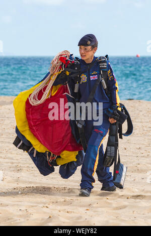 Bournemouth, UK. 30th August 2019. Tigers Freefall Parachute Display Team, British Army's Tigers fall from the sky and drop onto the beach. Female jumper from Army Parachute Display Team Royal Logistic Corps The Silver Stars collects her parachute after the jump, part of Bournemouth Air Festival. Credit: Carolyn Jenkins/Alamy Live News Stock Photo