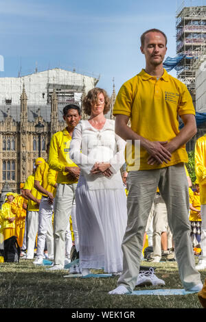 London, UK. 30th Aug 2019. Practitioners of the Chinese Falun Gong (also known as Falun Dafa) spiritual movement fill Parliament Square and surrounding areas and participate in a mass practice of their skills. Participants have come from all over Europe, including France, Germany, Italy and the UK, ahead of a conference in London tomorrow. Credit: Imageplotter/Alamy Live News Stock Photo