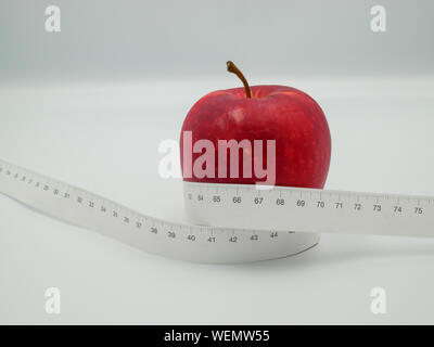 Red apple and yellow measuring tape to symbolize an healthy diet and body weight  control Stock Photo - Alamy