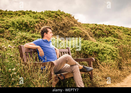 man sitting on a wooden bench thinking thinking about the future Stock Photo