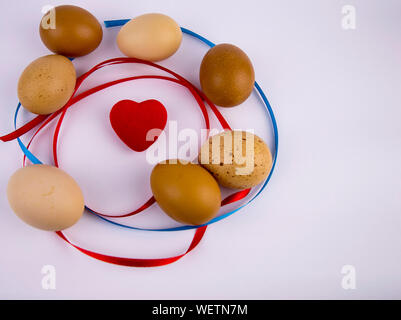 Easter eggs with a heart on a white background with free space to fill the text. Stock Photo