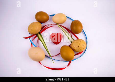 Easter eggs with a heart on a white background with free space to fill the text. Stock Photo