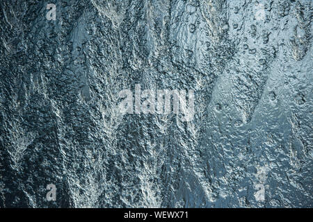 Blue all over background water wall with streaming water and bubbles Stock Photo